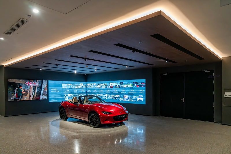 Xe trưng bày trước tường màn hình LED trong showroom ô tô
