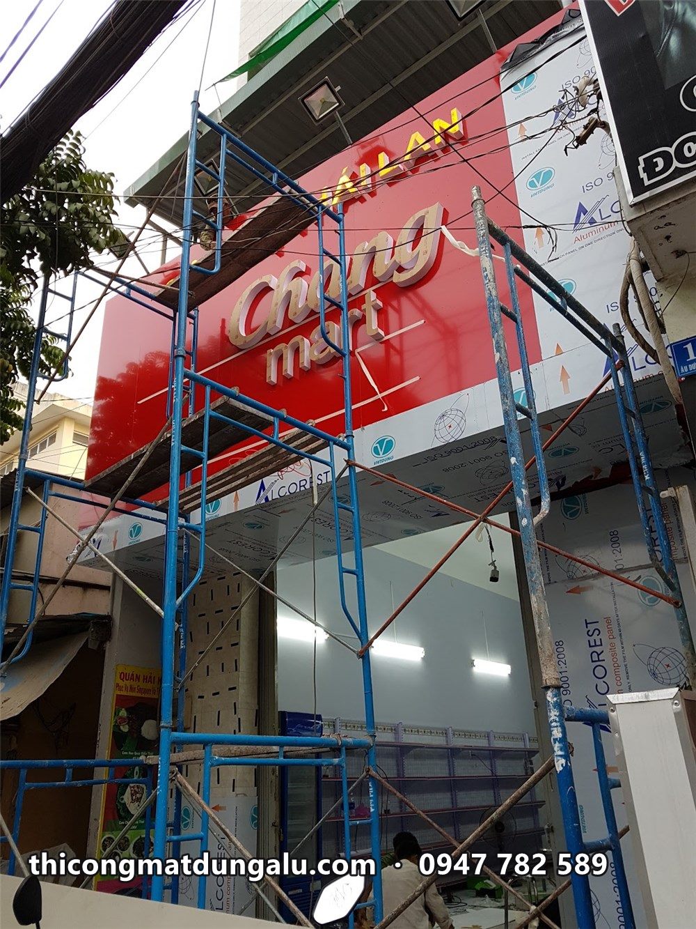 Bảng hiệu Chang Mart nền đỏ đang lắp trên giàn giáo