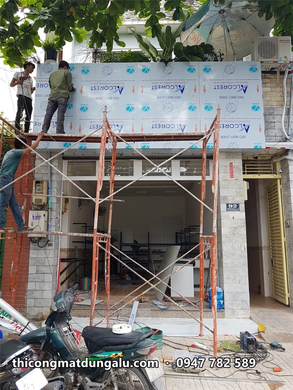 Giàn giáo trước mặt tiền Alle Mart, tấm alu còn màng bảo vệ