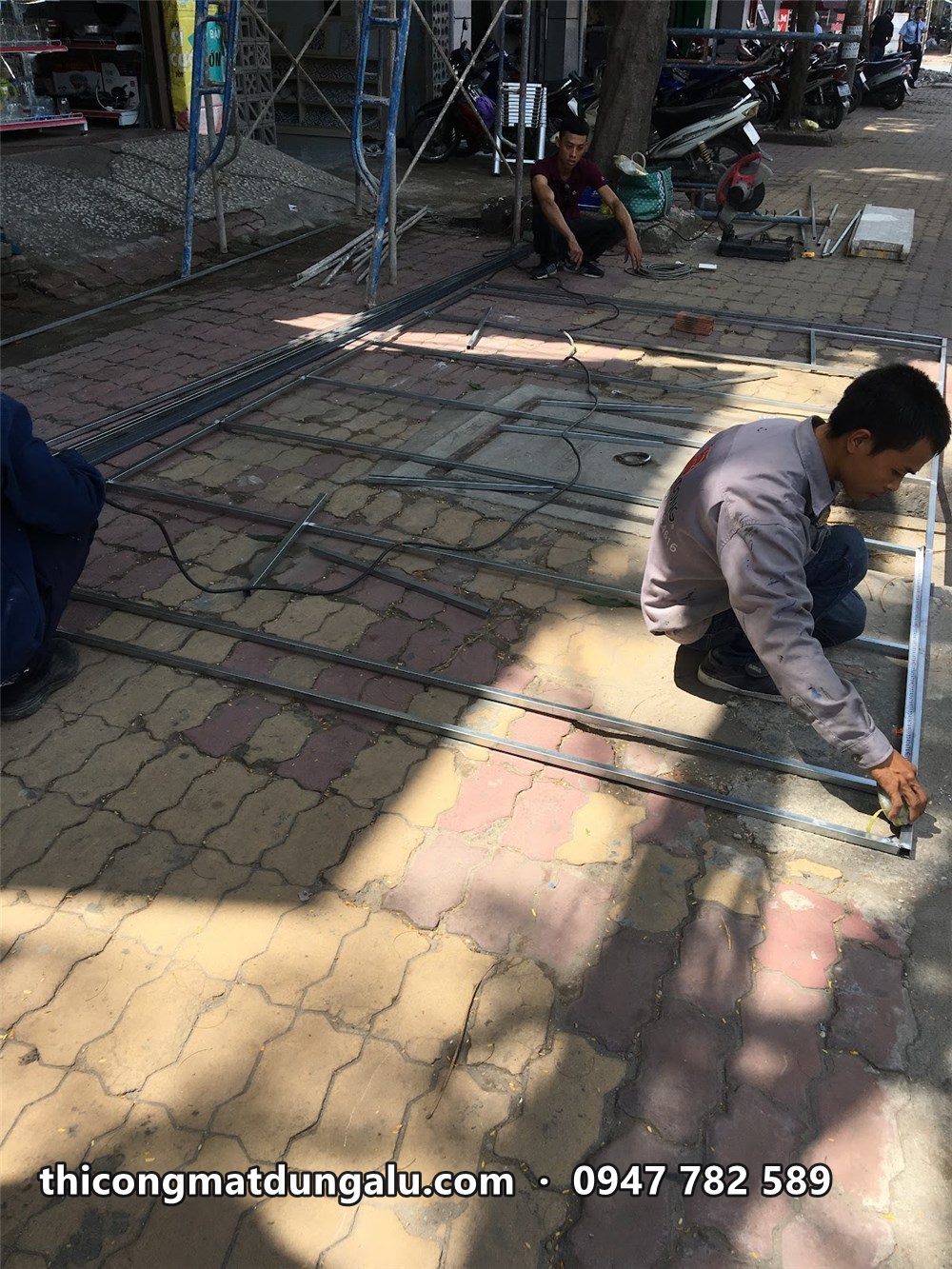 Thợ đo và lấy dấu trên vỉa hè trước khi lắp hộp đèn