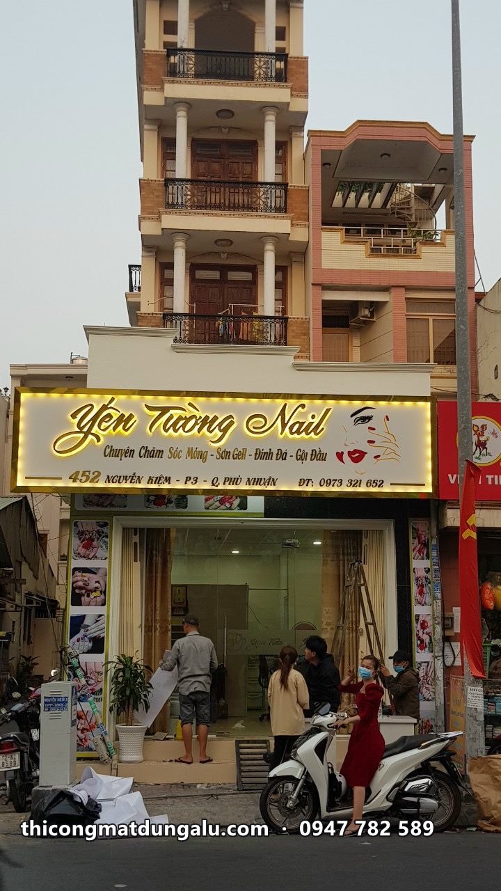Mặt tiền tiệm Yến Tường Nail với bảng chữ vàng trên nền kem, nhà phố nhiều tầng
