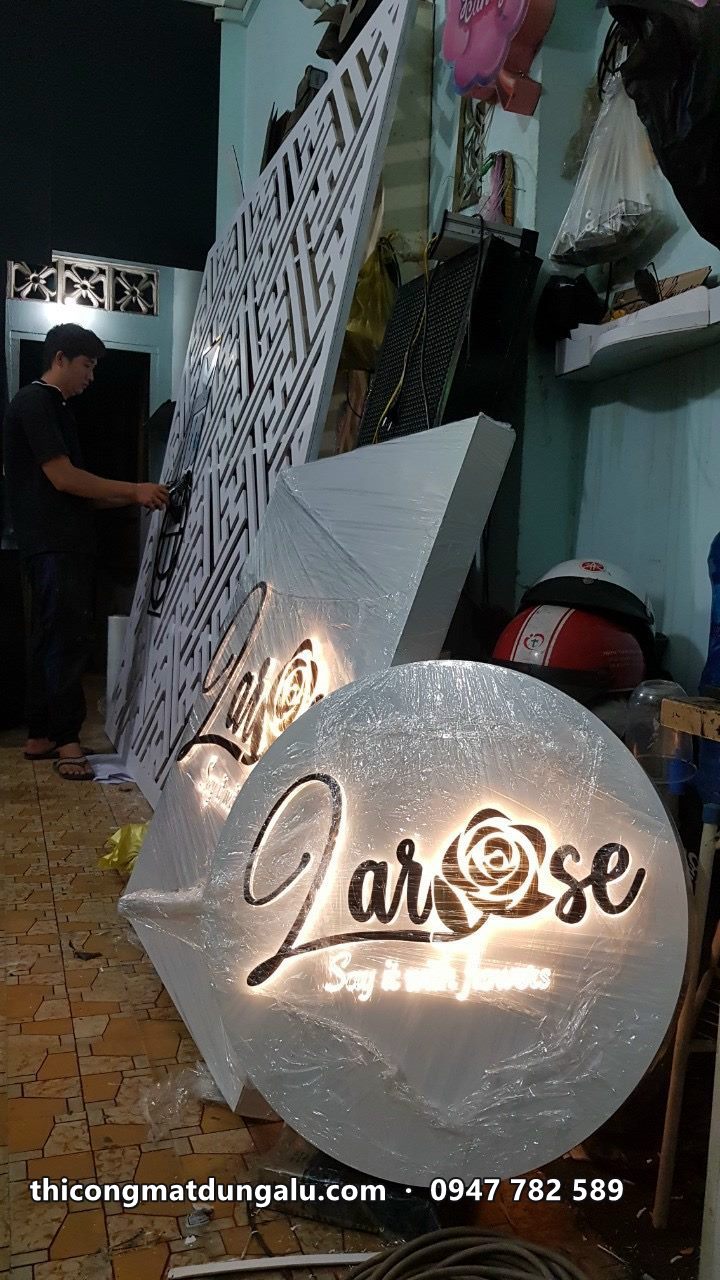 Logo tròn Larose hắt sáng vàng đặt trong xưởng