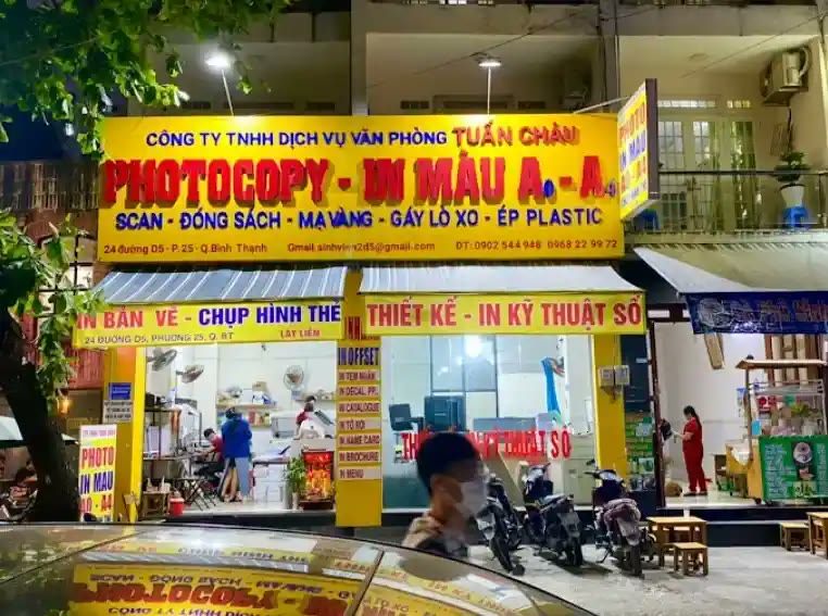 Bảng hiệu dịch vụ văn phòng nền vàng, chữ đỏ, liệt kê photocopy, in màu, đóng sách