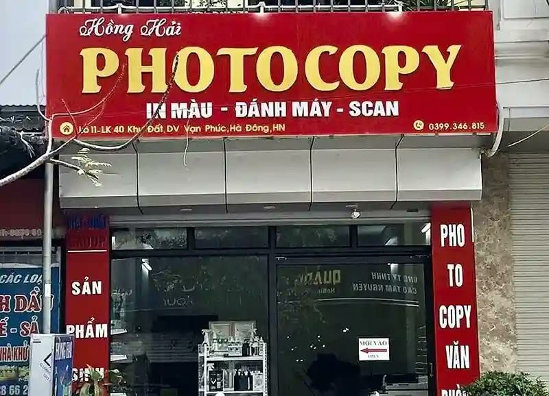 Bảng hiệu photocopy Hồng Hải nền đỏ, chữ nổi vàng và biển dọc