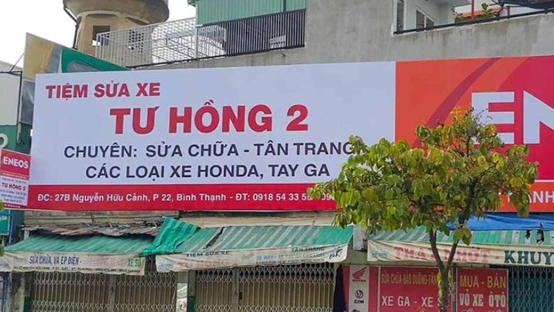 Bảng bạt tiệm sửa xe nền trắng chữ đỏ ghi rõ dịch vụ