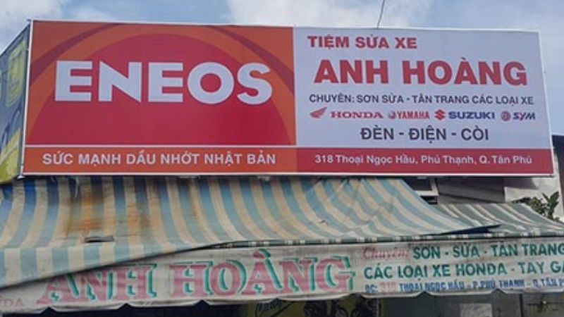 Bảng hiệu tiệm sửa xe tài trợ dầu nhớt, logo hãng bên trái và tên tiệm bên phải