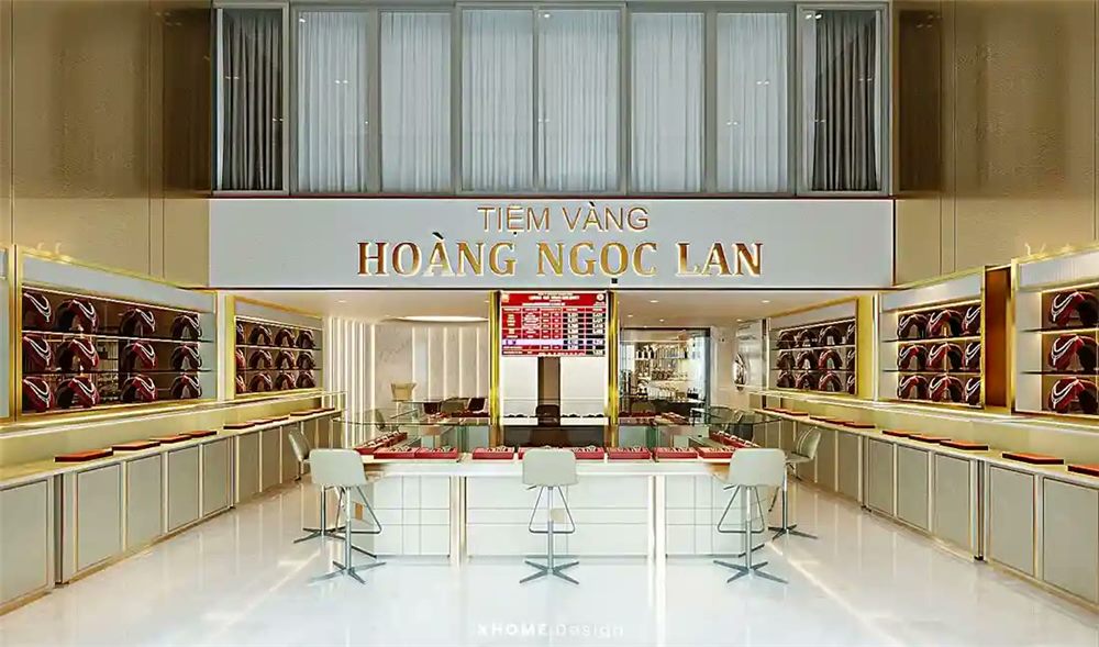 Nội thất tiệm vàng tông trắng với bảng tên chữ inox phía sau quầy