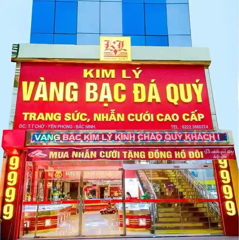 Cửa hàng vàng bạc đá quý nhiều tầng với bảng hiệu đỏ và dải chữ chạy