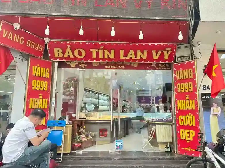Tiệm vàng với bảng tên đỏ và các dải dọc Vàng 9999 Nhẫn cưới