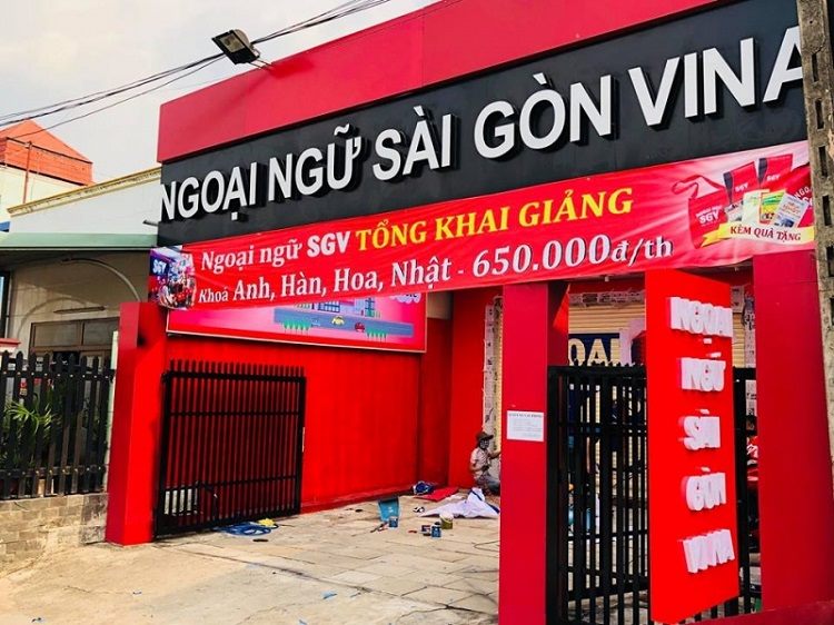 Trung tâm ngoại ngữ ốp đỏ với chữ nổi trắng lớn và bảng khai giảng