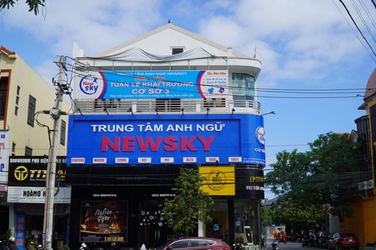 Trung tâm anh ngữ với bảng xanh chữ đỏ và băng rôn khai trương