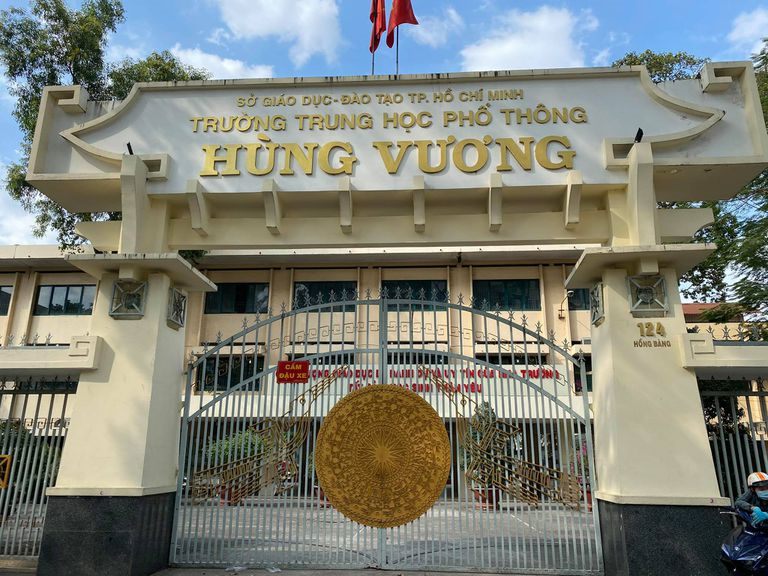Cổng trường trung học phổ thông với chữ nổi vàng gắn trên cổng xây