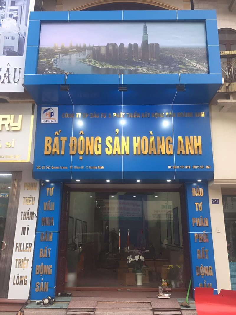 Mặt tiền văn phòng bất động sản ốp alu xanh dương với hộp đèn in ảnh thành phố