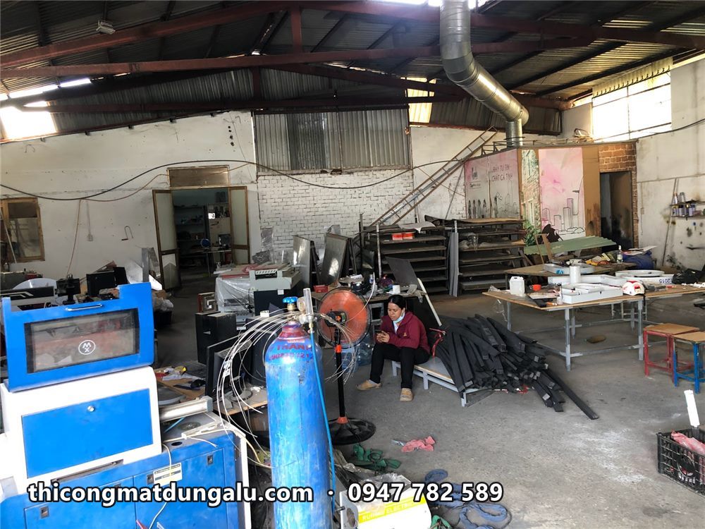 Góc xưởng có máy cắt, bình khí và khung sắt