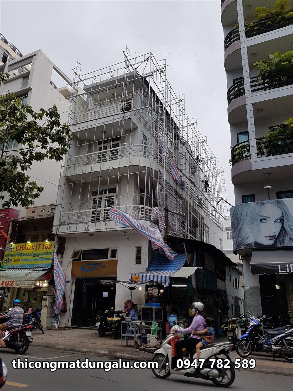 Giàn giáo dựng kín nhà phố góc đường, khung xương bắt trên ban công