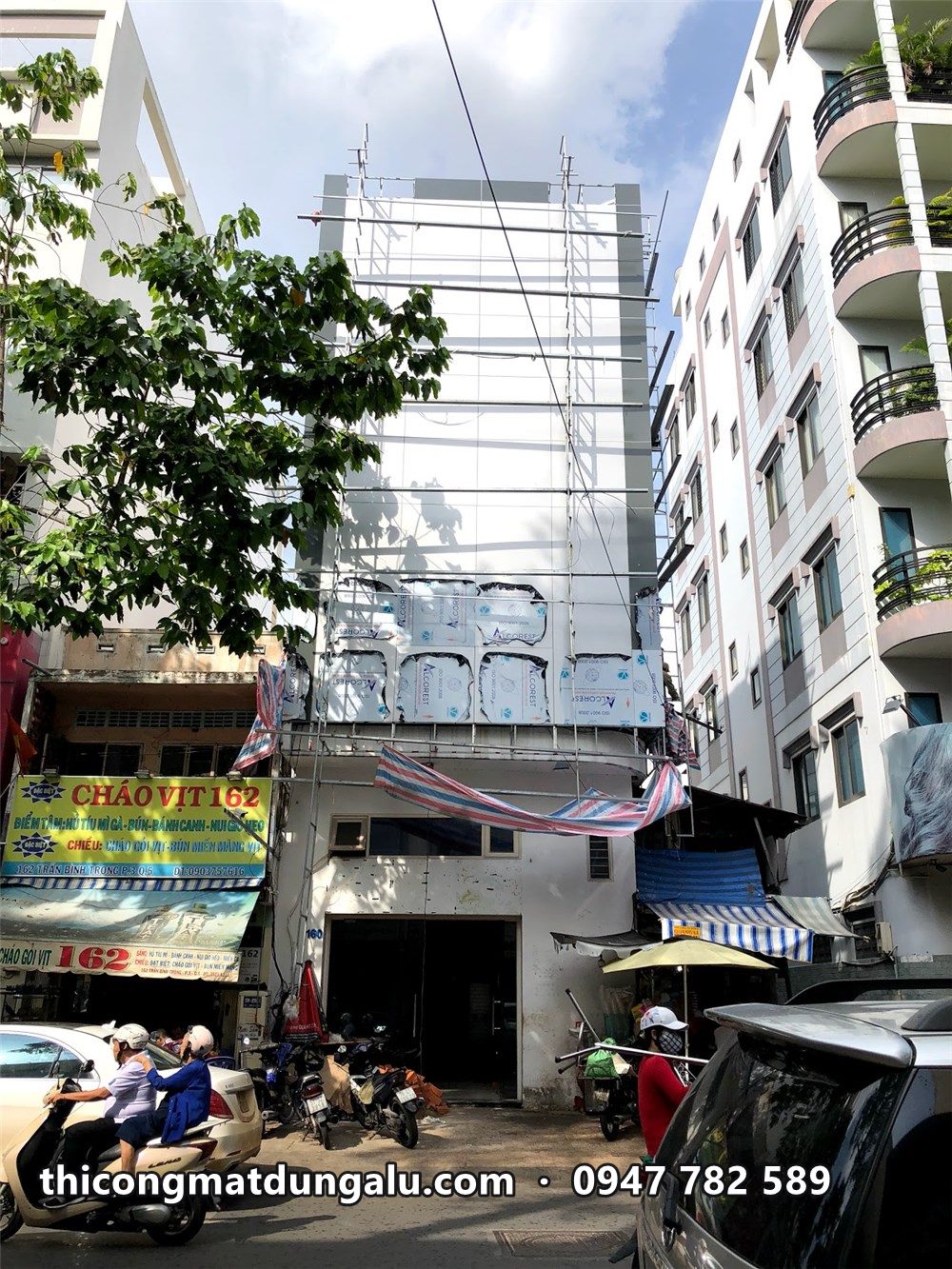 Nhà phố góc đường sau khi ốp alu trắng, giàn giáo đang tháo