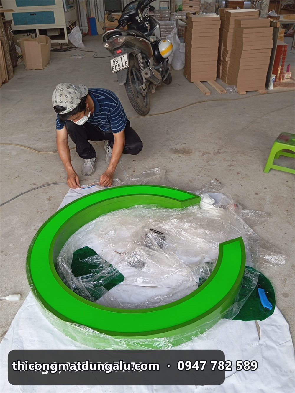 Thợ quấn màng bảo vệ cho chữ C cỡ lớn trong xưởng trước khi vận chuyển