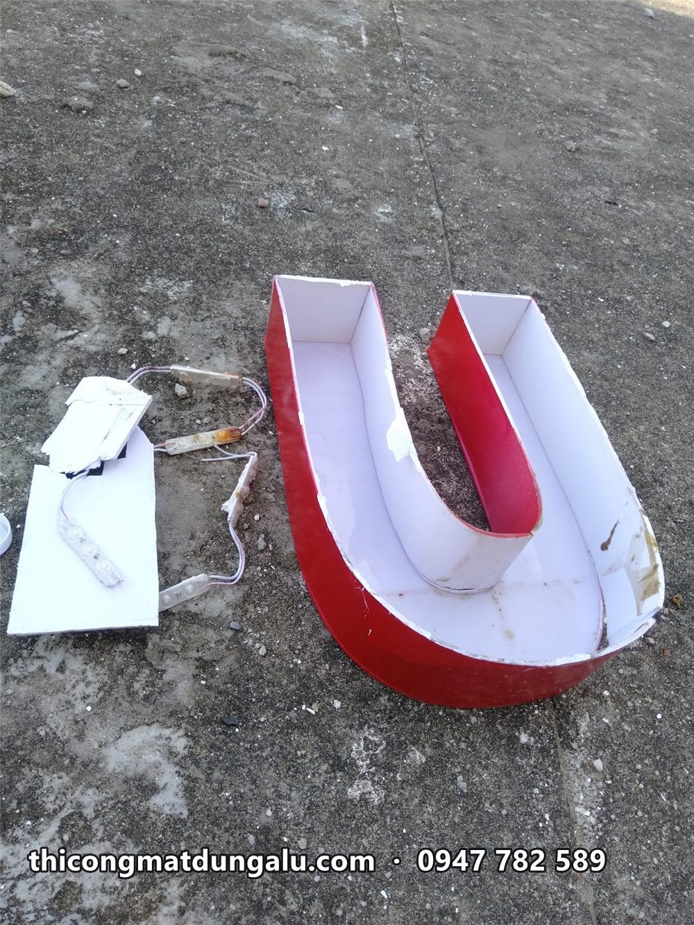 Chữ U mặt đỏ thành trắng đặt trên sân thượng cạnh cuộn đèn LED