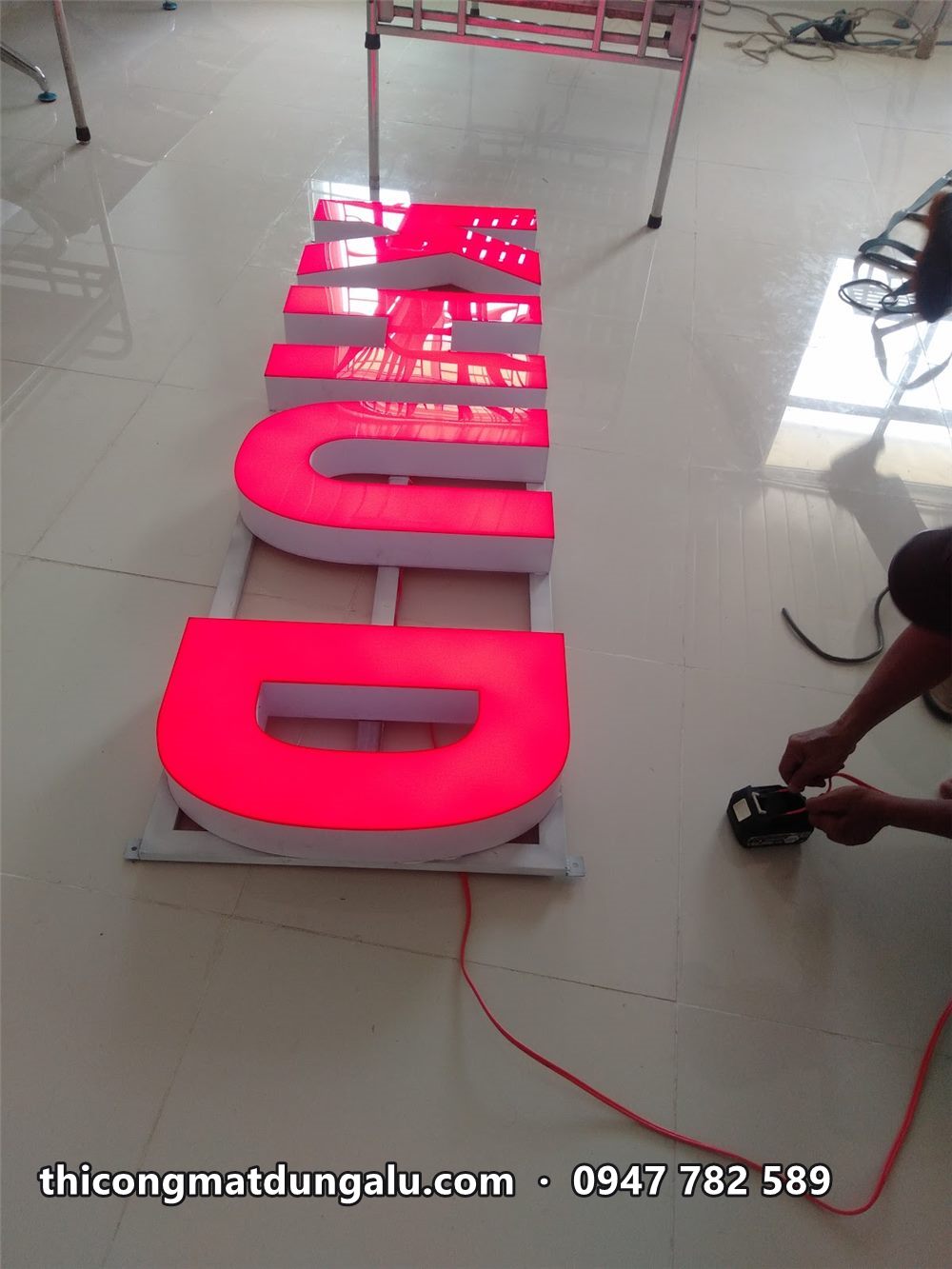 Chữ KHU D phát sáng đỏ khi thử đèn trên sàn gạch