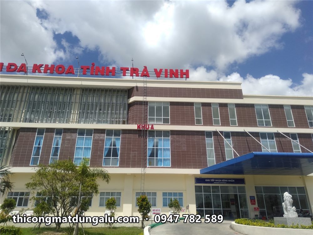 Dãy chữ đỏ Bệnh viện Đa khoa tỉnh Trà Vinh trên mái khối nhà mặt gạch nâu và kính