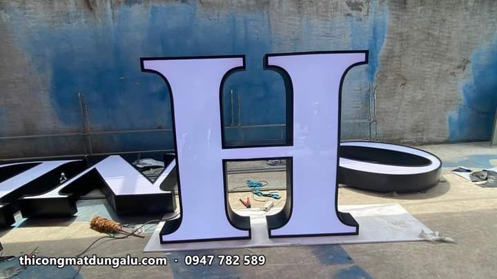 Chữ H viền đen mặt trắng dựng đứng trên sân xưởng