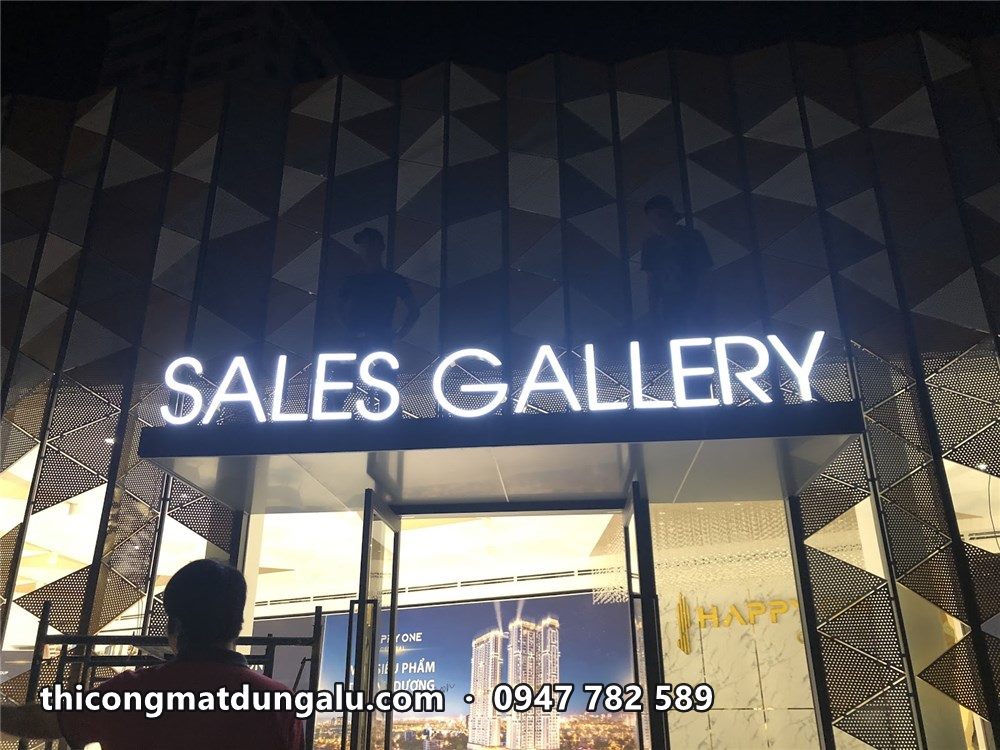 Chữ Sales Gallery trắng sáng trên mái đón lối vào nhà mẫu ban đêm