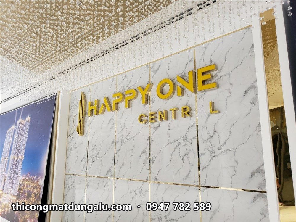 Chữ Happy One Central màu vàng trên vách đá trắng trong sảnh