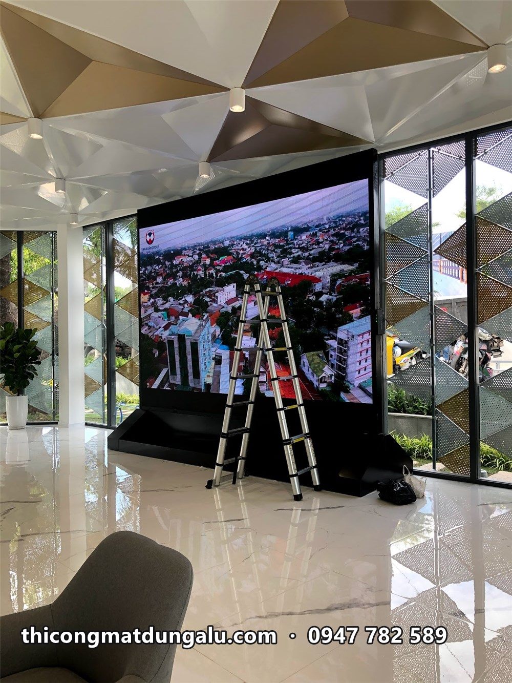 Màn hình LED lớn trong sảnh nhà mẫu sát vách kính, thang nhôm bên cạnh