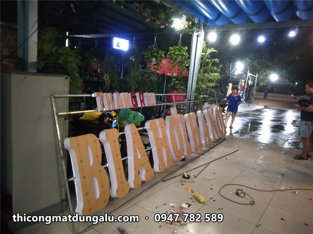 Cụm chữ trên khung đặt nghiêng chuẩn bị dựng lên, có dòng chữ đỏ nhỏ phía trên