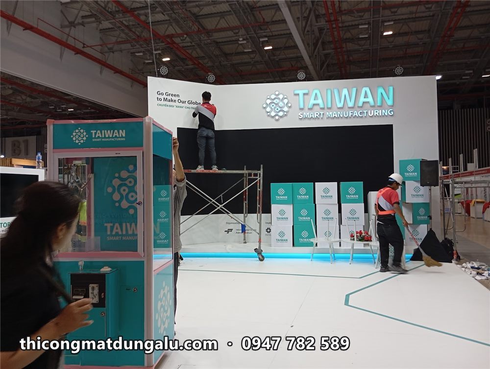 Khu trưng bày Taiwan với vách xanh ngọc, máy trưng bày và thợ trên giàn giáo