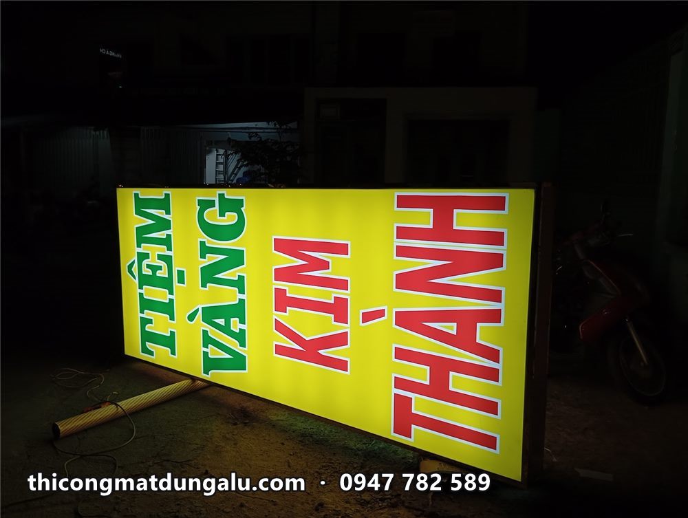 Hộp đèn Kim Thành nhìn chéo trong xưởng tối, chữ Thành đỏ nổi bật