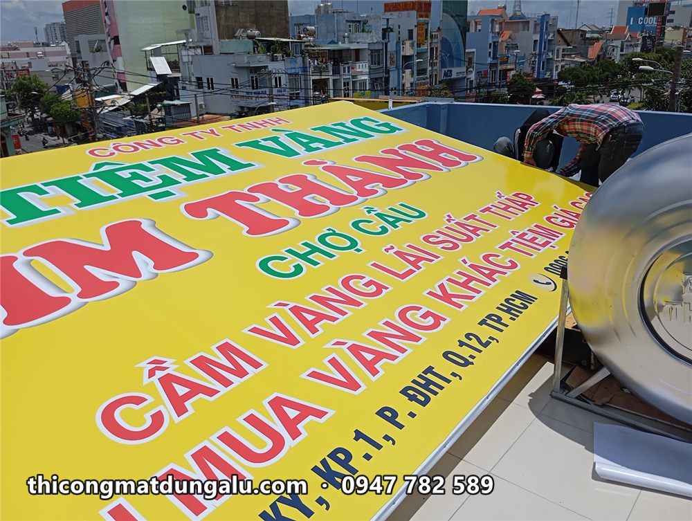 Bảng hiệu ngang Tiệm Vàng Kim Thành nền vàng chữ đỏ đặt trên sân thượng trước khi lắp