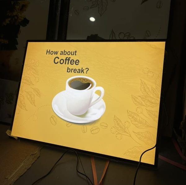 Hộp đèn mỏng mặt in hình ly cà phê đặt trên quầy