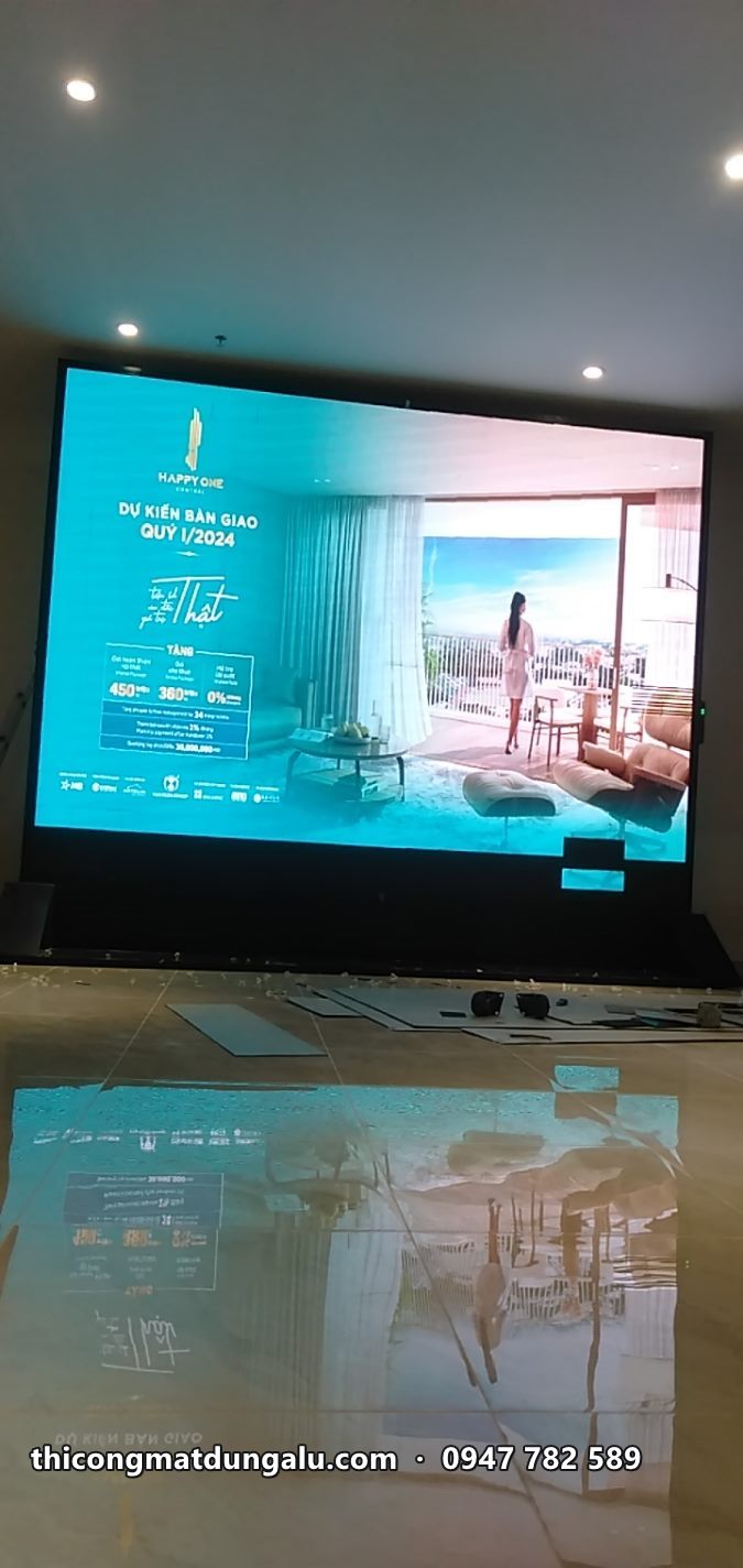 Màn hình LED trong phòng trưng bày chiếu hình quảng cáo căn hộ, phản chiếu trên sàn bóng