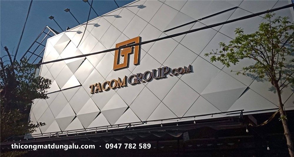 Logo Tacom Group vàng trên mặt dựng tam giác bạc nhìn từ đường