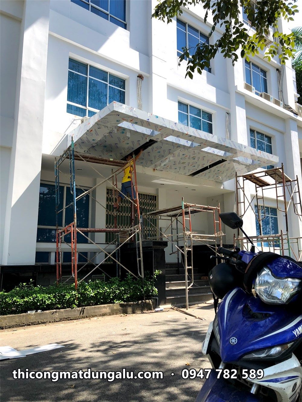 Mái đón lối vào nhìn từ bên hông, xe máy đậu phía trước