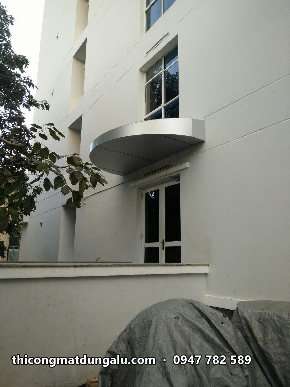 Mái vòm nhỏ ốp alu bạc trên cửa sổ hông tòa nhà