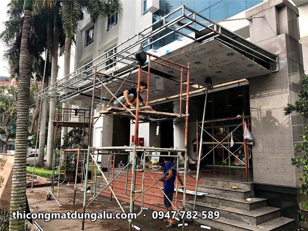 Khung mái sảnh nhô ra trước bậc tam cấp, giàn giáo đỡ bên dưới