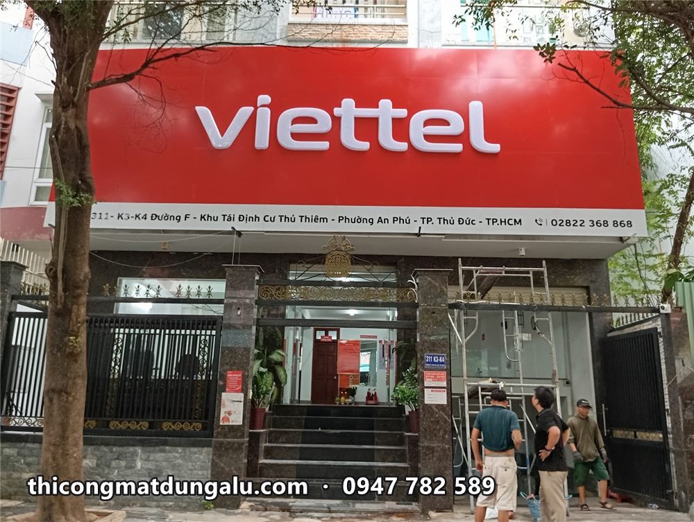 Mặt tiền cửa hàng Viettel với mặt dựng alu đỏ chữ trắng vừa lắp, thợ đứng phía dưới