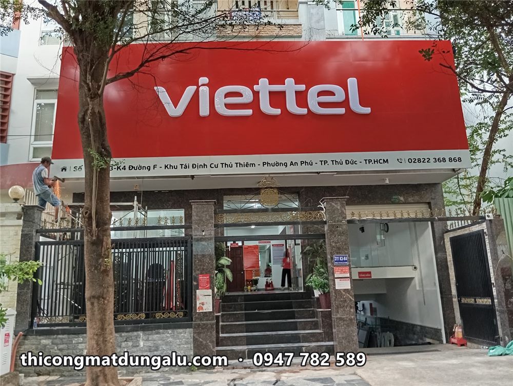 Cửa hàng Viettel hoàn thiện với mặt dựng alu đỏ, chữ viettel trắng và hàng cây phía trước