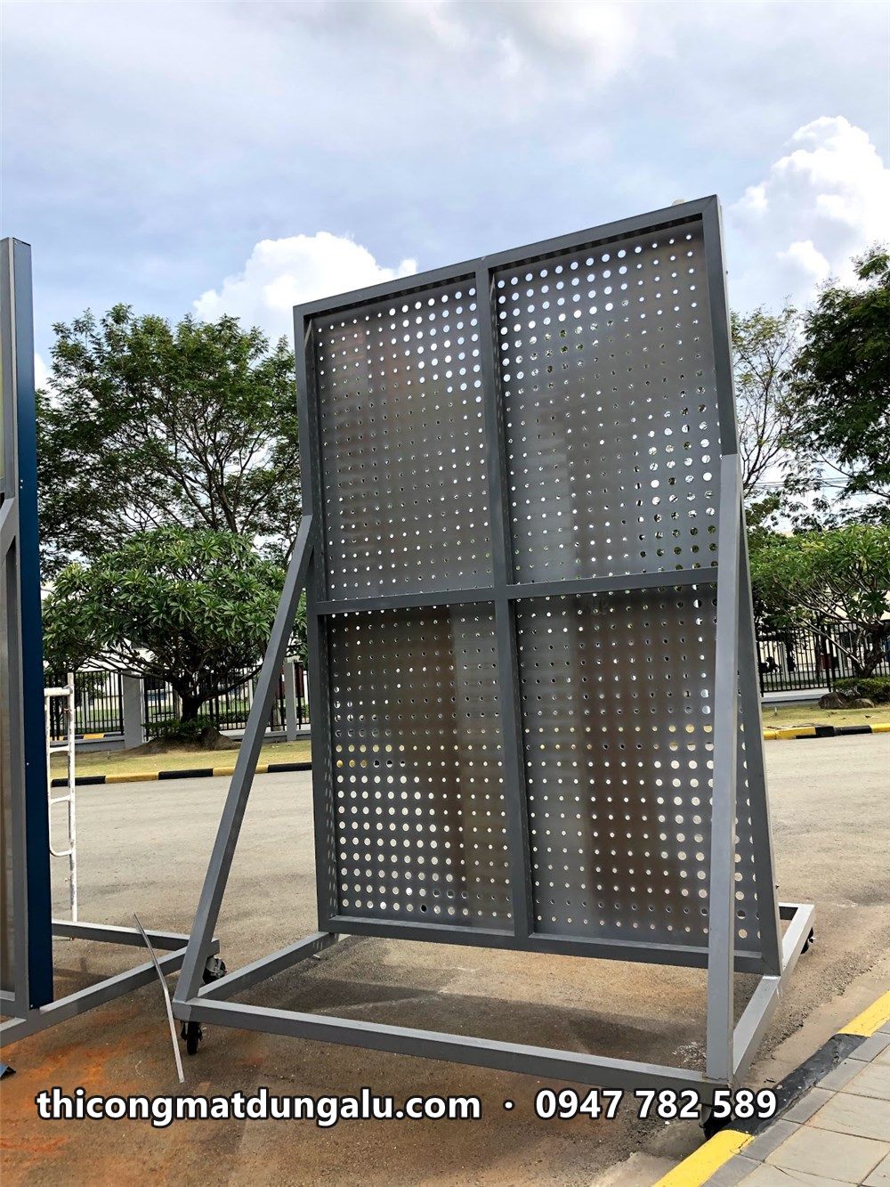 Cận cảnh tấm alu mẫu đục lỗ tròn chia bốn ô, dựng trên khung chân đế