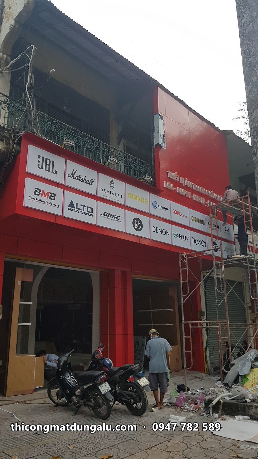 Tầng trệt cửa hàng hoàn thiện alu đỏ với bảng logo các hãng âm thanh