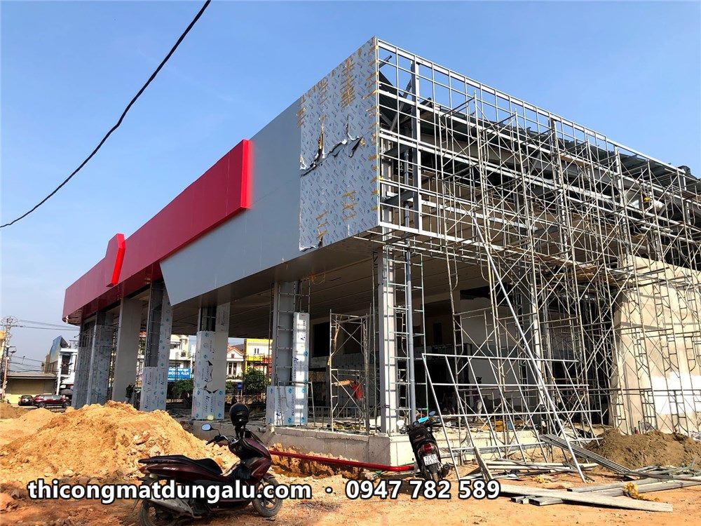 Showroom VinFast với khối trắng và dải đỏ đang hoàn thiện, giàn giáo vẫn còn