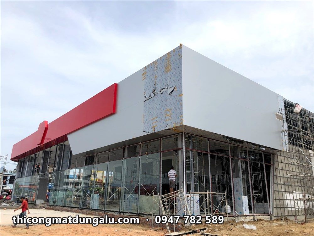 Khối hộp trắng góc showroom gần hoàn thiện, mặt kính bên dưới đã lắp