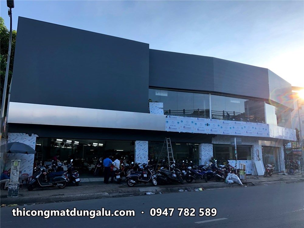 Showroom góc đường nhìn dọc mặt tiền, nắng chiều chiếu vào góc bo