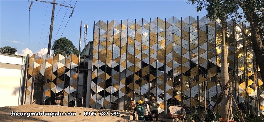 Toàn cảnh mặt dựng tam giác ba màu đang hoàn thiện, cây xanh phía trước