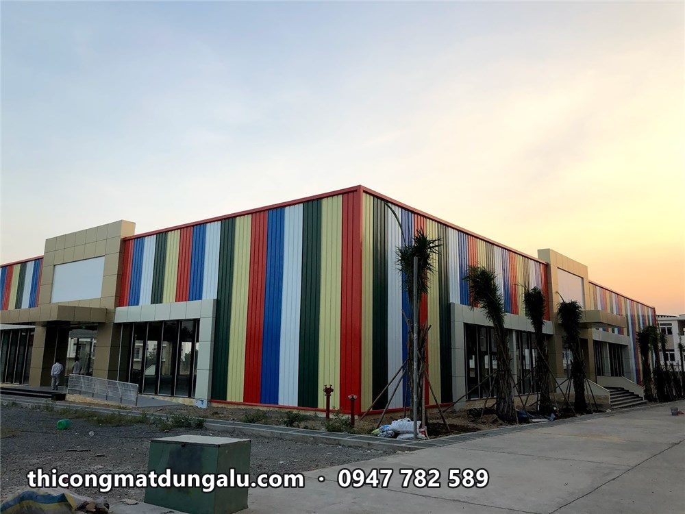 Trung tâm thương mại sọc màu lúc chiều tối, cây cảnh mới trồng phía trước