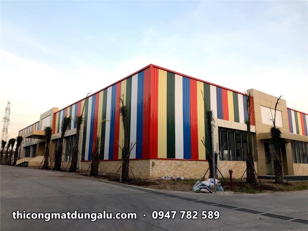Góc trung tâm thương mại với các sọc đỏ vàng xanh trắng chạy quanh hai mặt nhà