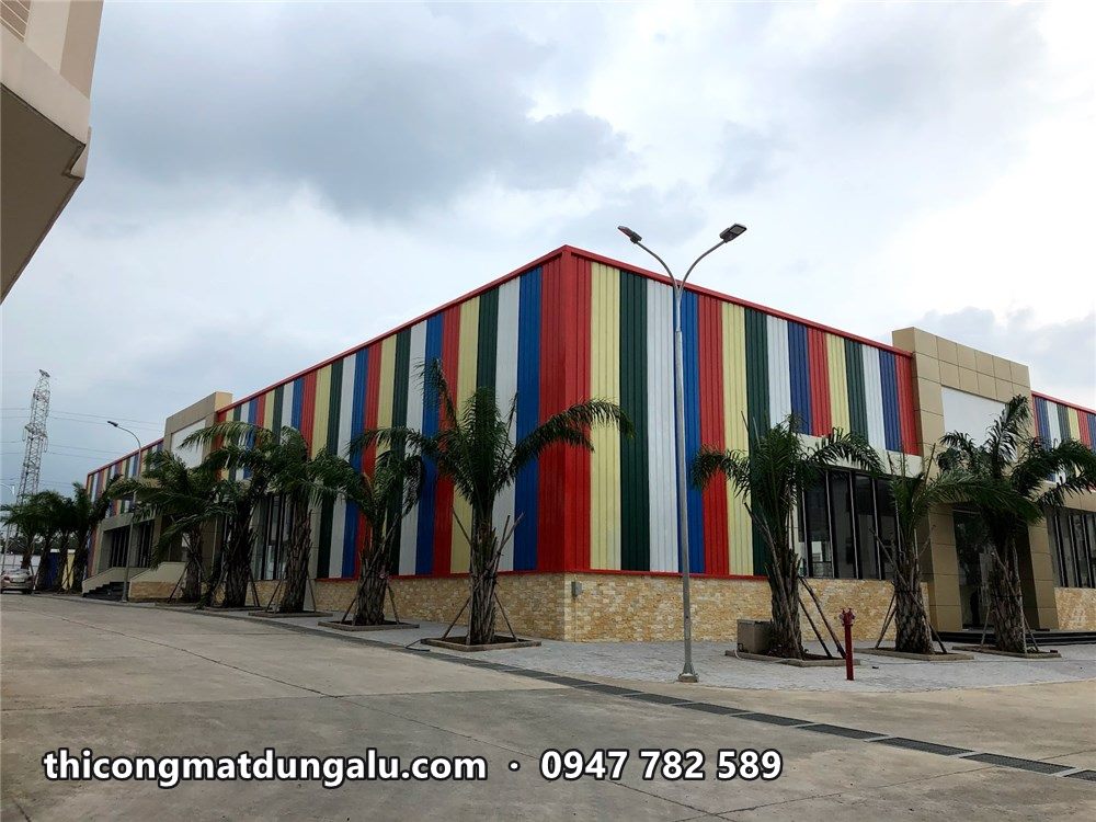 Trung tâm thương mại sọc màu nhìn từ đường, hàng cau và cột đèn phía trước
