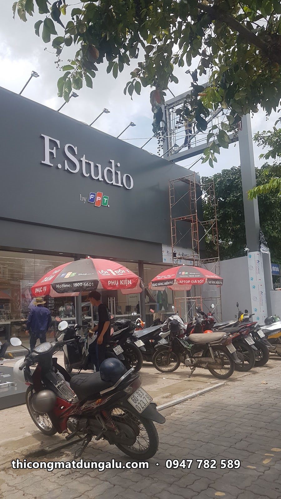 Cửa hàng F.Studio by FPT với mặt dựng xám đậm và logo trắng, dù đỏ phía trước